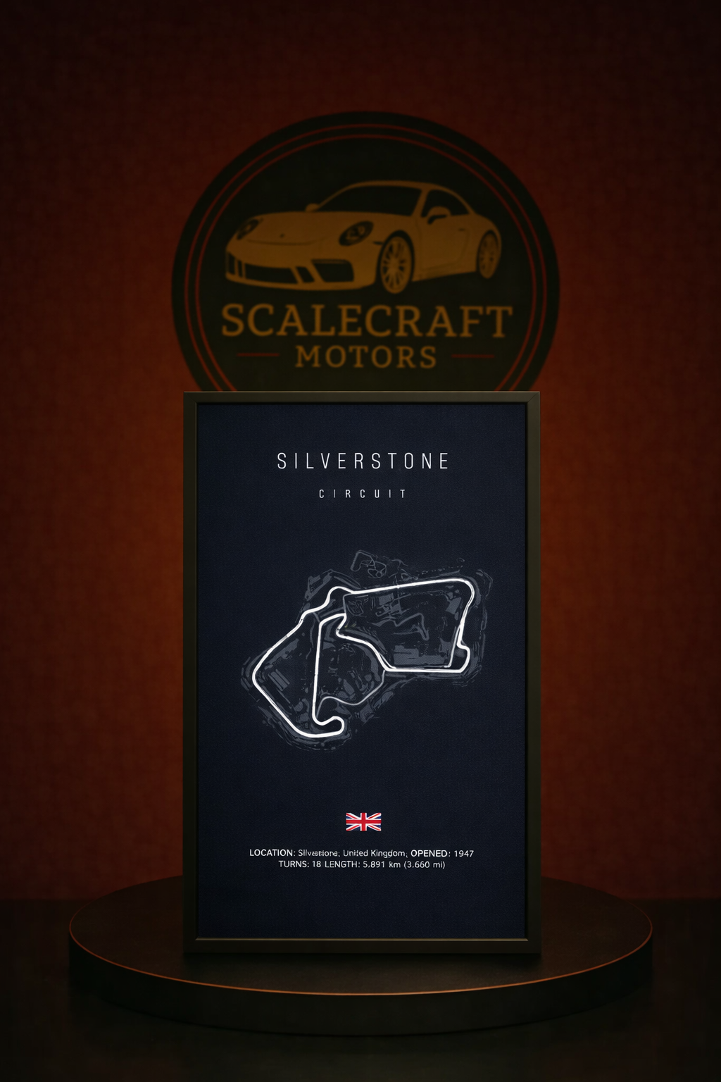 Framed Silverstone Circuit print on a round wooden table against ScaleCraft Motors logo backdrop
